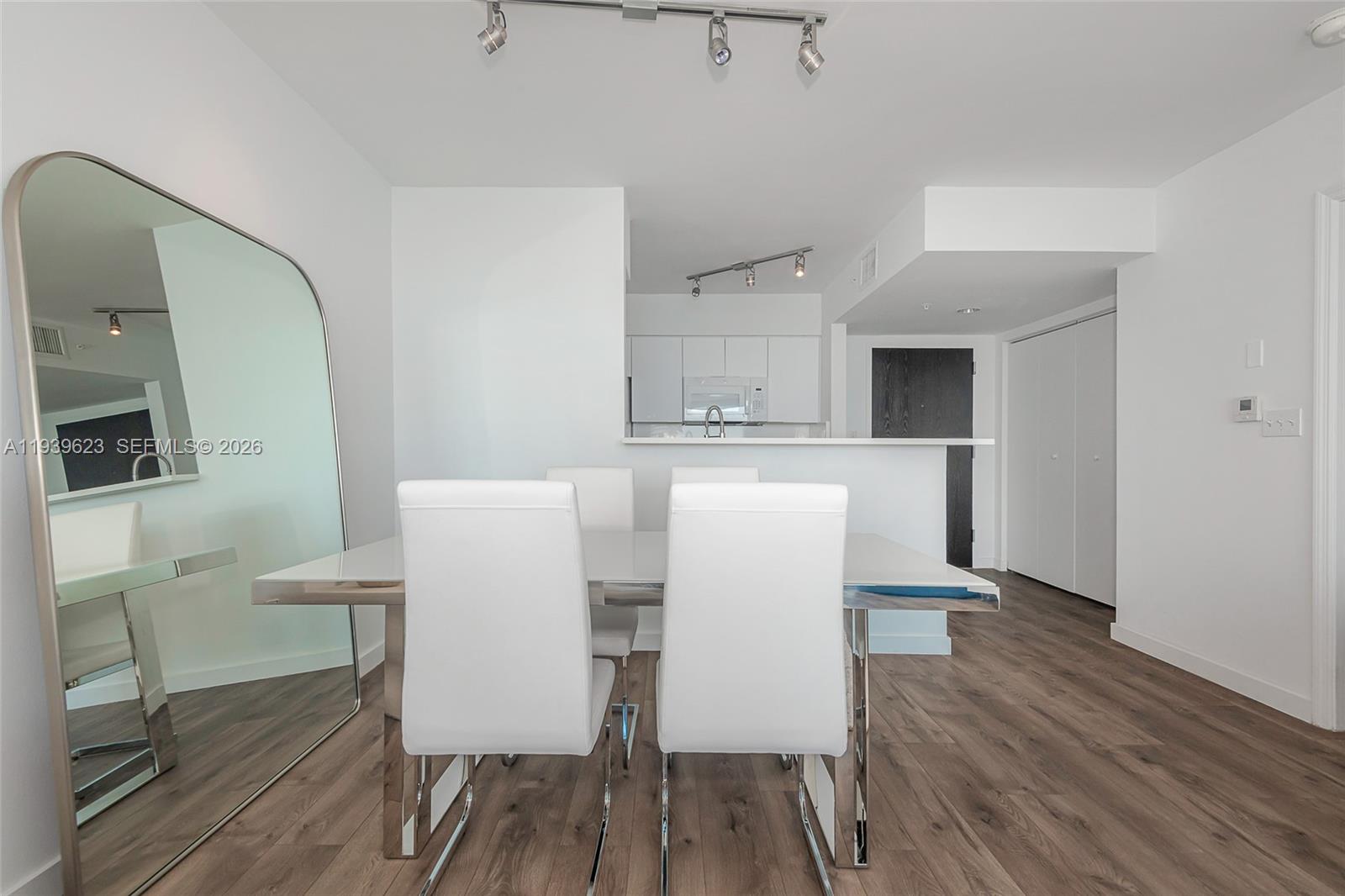 90 Alton Road, Unit 2008 Miami Beach, FL 33139 - Photo 13 of 28 a view of a dining room with furniture and wooden floor