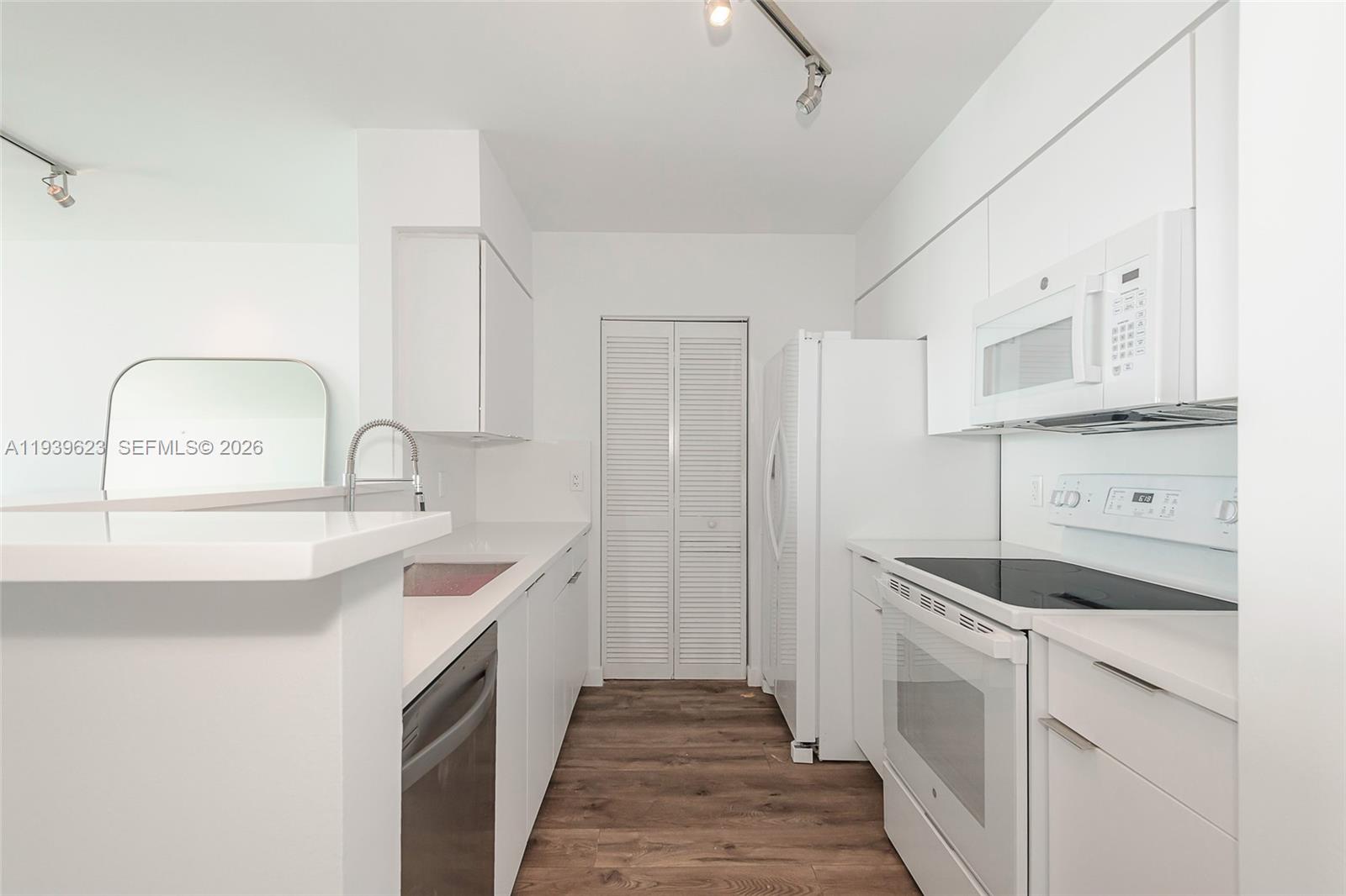 90 Alton Road, Unit 2008 Miami Beach, FL 33139 - Photo 16 of 28 a kitchen with a sink stove and cabinets