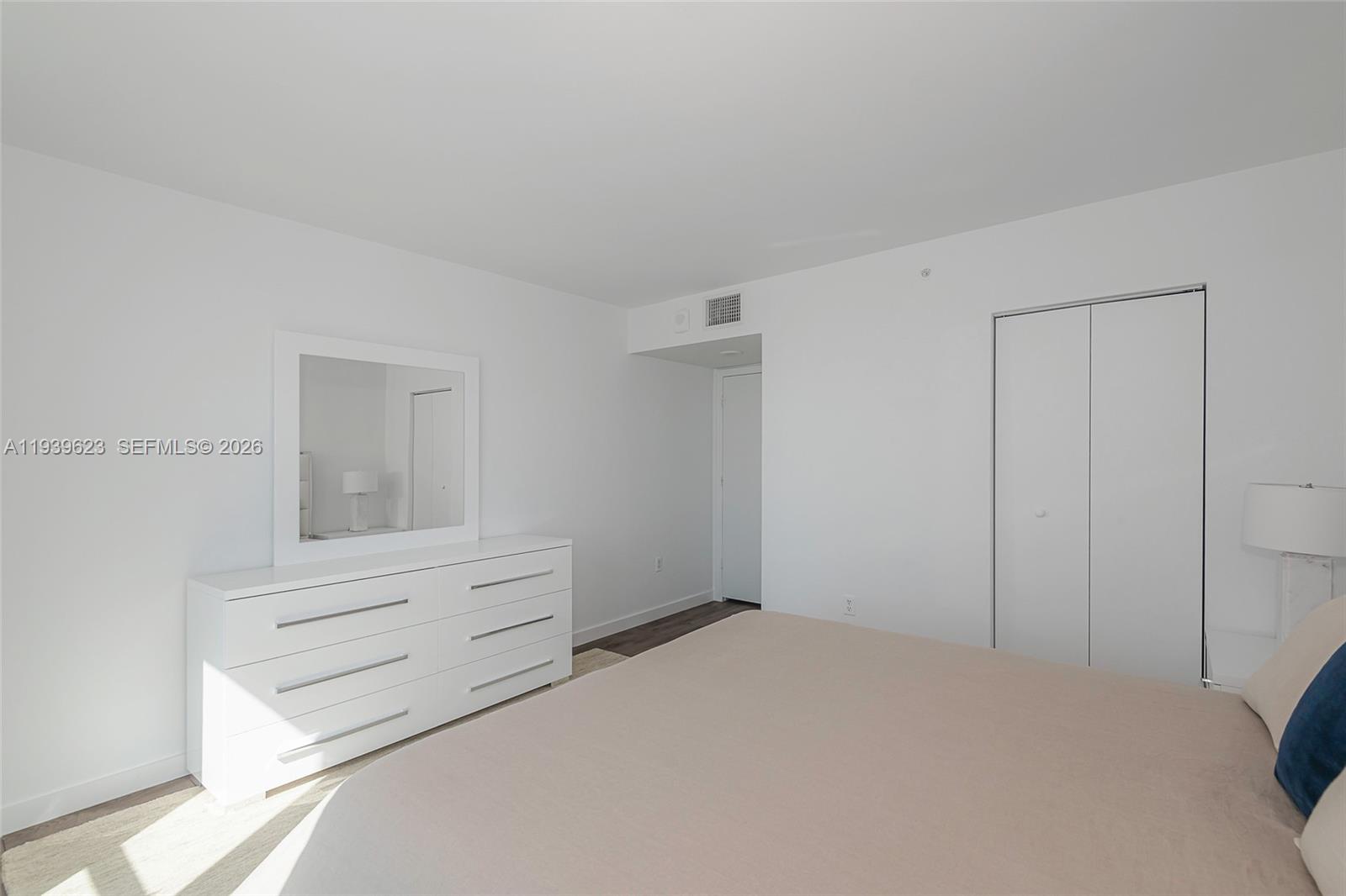 90 Alton Road, Unit 2008 Miami Beach, FL 33139 - Photo 22 of 28 a room with a bed and cabinet