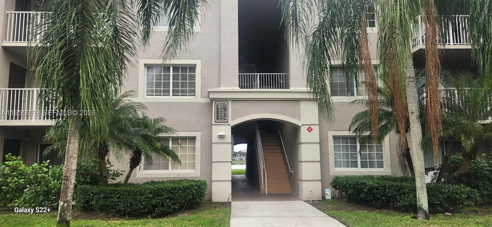 5011 Wiles Road, Unit 306 Coconut Creek, FL 33073 - Photo 5 of 17 a front view of a house with plants and garden