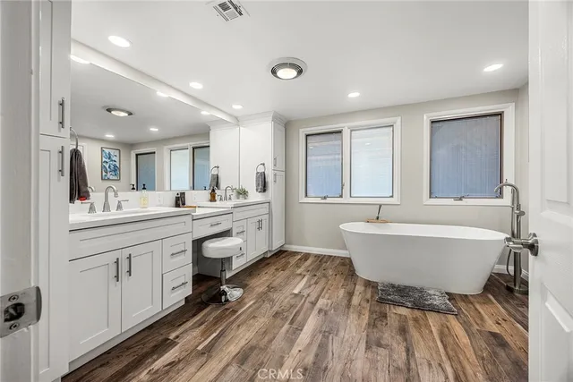 a large bathroom with a large tub sink and glass door