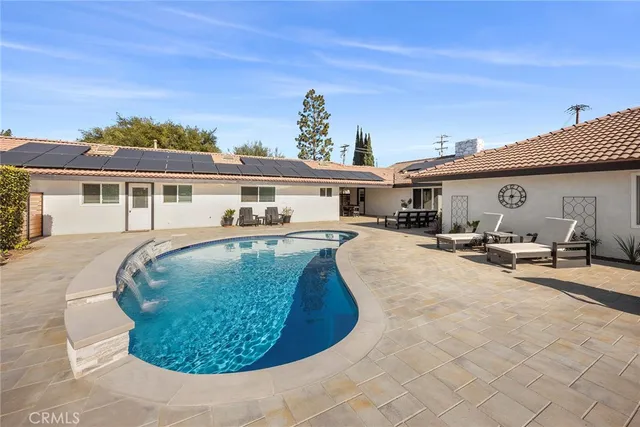 a view of a white house with swimming pool and sitting area