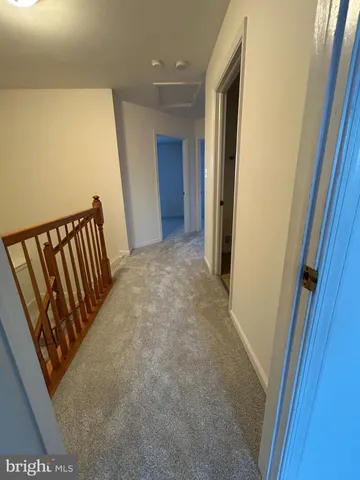 a view of a hallway with wooden floor and stairs