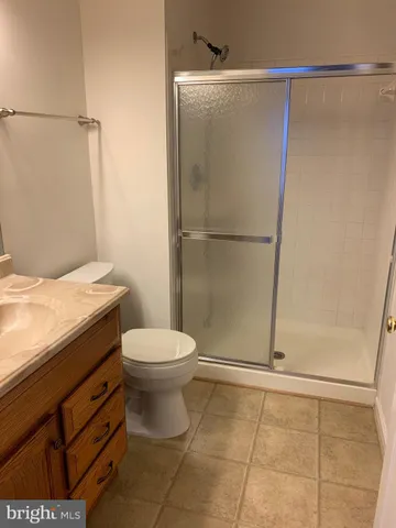a bathroom with a granite countertop shower and a toilet