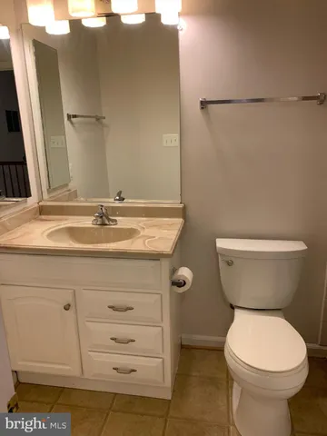 a bathroom with a granite countertop toilet and a sink