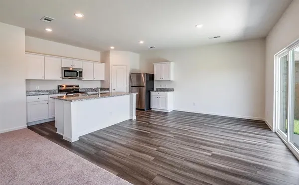 a kitchen with stainless steel appliances granite countertop a stove a sink and a refrigerator