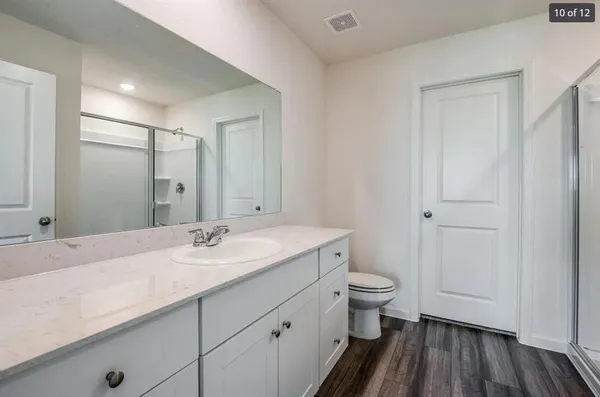 a bathroom with a sink a toilet a shower and a mirror