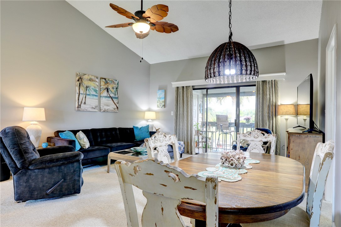 5725 Pelican Pointe Drive, Unit 4 Sebastian, FL 32958 - Photo 14 of 36 a view of a dining room with furniture wooden floor and chandelier
