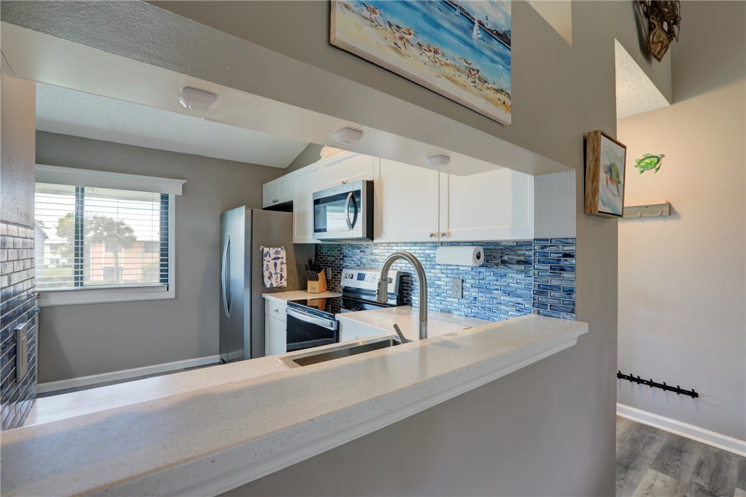 5725 Pelican Pointe Drive, Unit 4 Sebastian, FL 32958 - Photo 15 of 36 a kitchen with granite countertop a stove a sink and a microwave