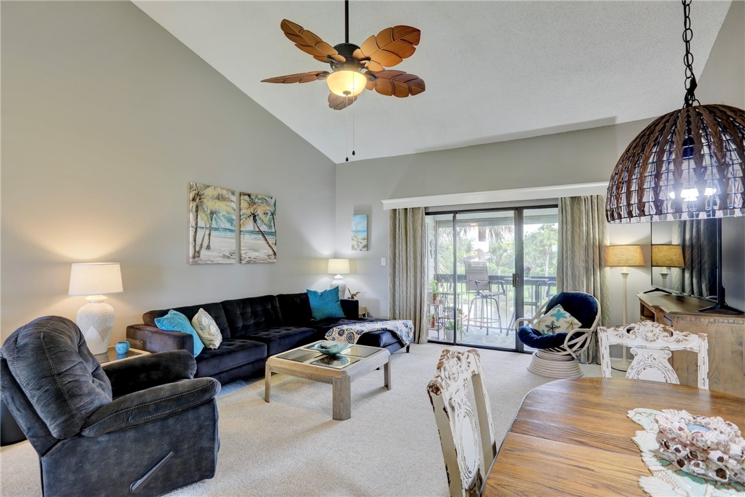 5725 Pelican Pointe Drive, Unit 4 Sebastian, FL 32958 - Photo 10 of 36 a living room with furniture ceiling fan and a large window