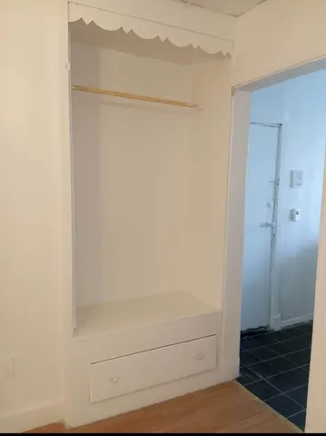 a view of a room with an empty space and wooden floor