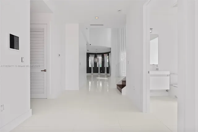 a large kitchen with stainless steel appliances a large counter top and a refrigerator