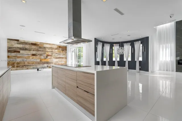 a view of an empty room with wooden floor and a bathroom