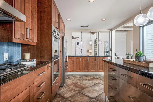 a kitchen with stainless steel appliances a sink stove and cabinets