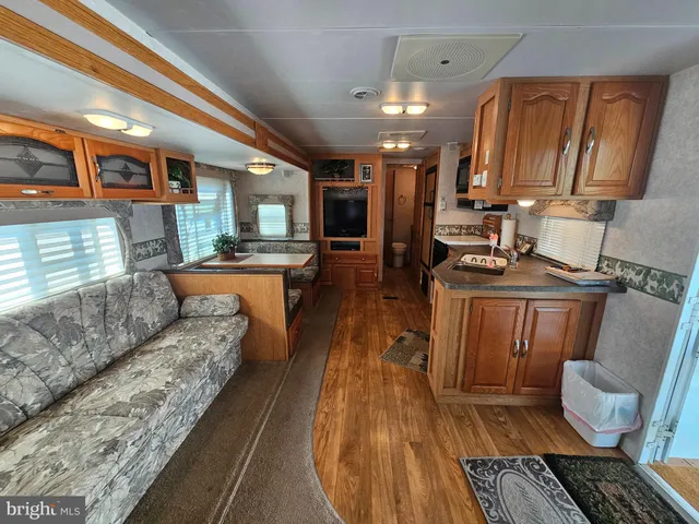 a kitchen with stainless steel appliances granite countertop a refrigerator a stove and a sink with wooden cabinets