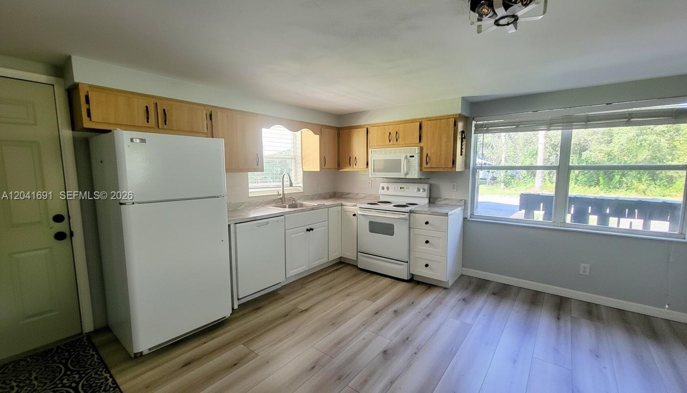 1270 Nobles Road LaBelle, FL 33935 - Photo 5 of 18 a kitchen with stainless steel appliances a refrigerator sink and wooden floor