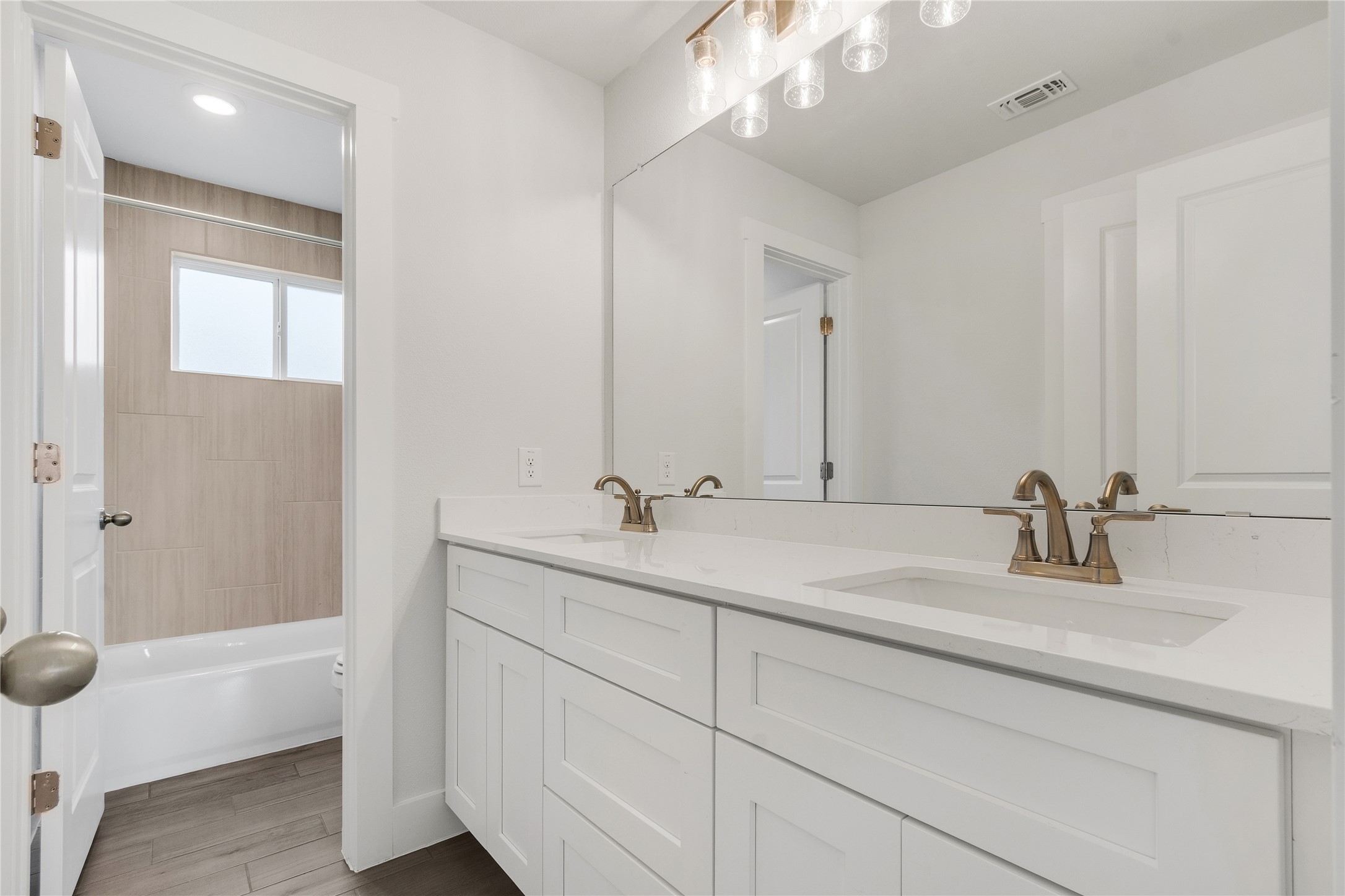 8500 Red Bottle Brush Road Lago Vista, TX 78645 - Photo 25 of 33 Double vanity in this primary bathroom offers ample counter space and storage, complemented by a contemporary tub-shower combo.