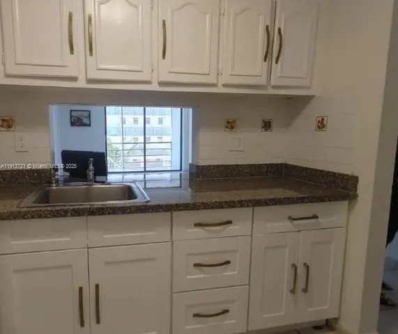 a kitchen with white cabinets and a sink