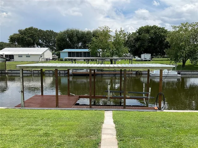 a kitchen with stainless steel appliances granite countertop a refrigerator a stove and a dining table with wooden floor