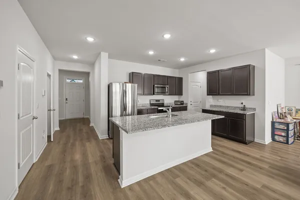 a kitchen with stainless steel appliances granite countertop a refrigerator stove a sink and dishwasher with wooden floor