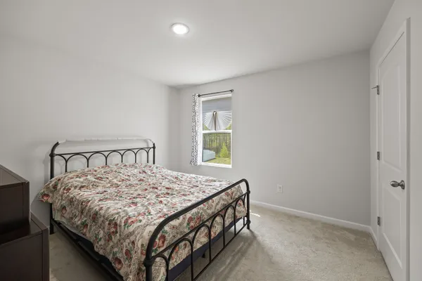 a bed sitting in a bedroom next to a window