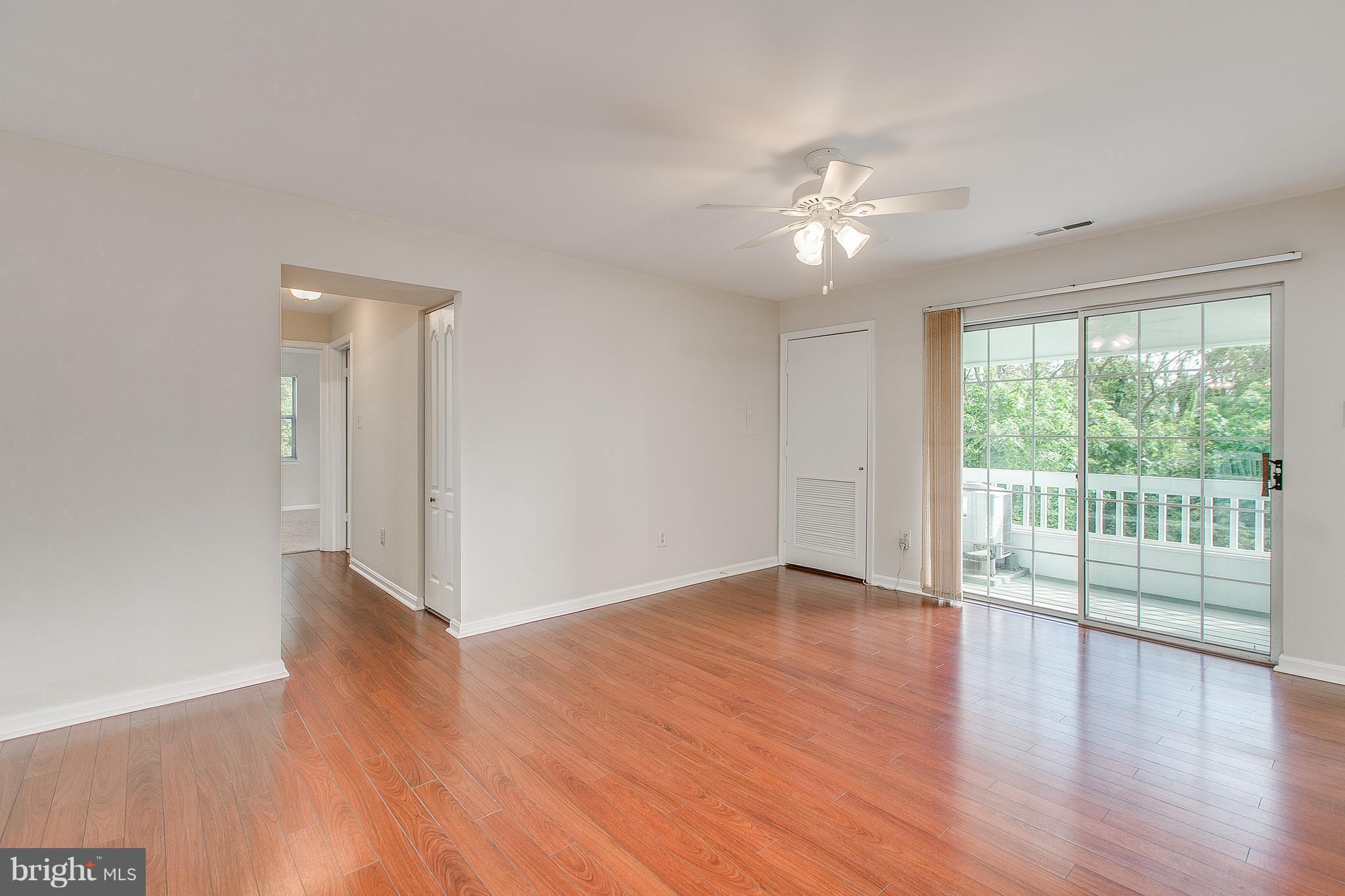 8601 Falls Run Road, Unit F Ellicott City, MD 21043 - Photo 2 of 17 a view of an empty room with wooden floor and a window