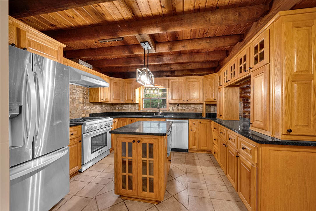 237 Spring Valley Road Liberty, SC 29657 - Photo 7 of 50 A rustic-chic kitchen featuring natural wood cabinetry, robust exposed ceiling beams, and contemporary stainless steel appliances.