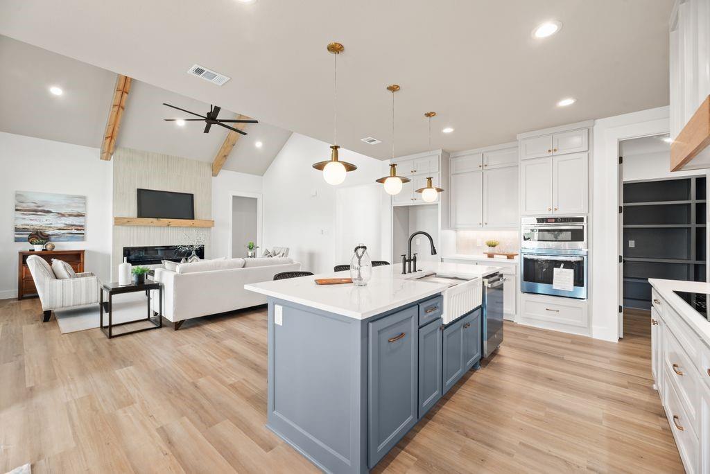 a large kitchen with stainless steel appliances kitchen island granite countertop a large center island and a sink