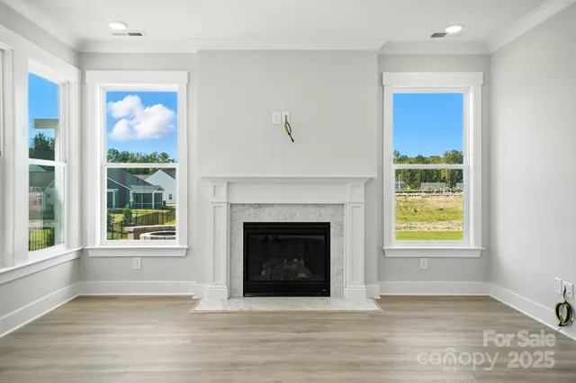 a view of a living room with wooden floor and a fireplace