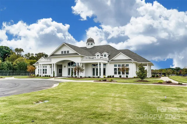 a living room with furniture kitchen view and a wooden floor