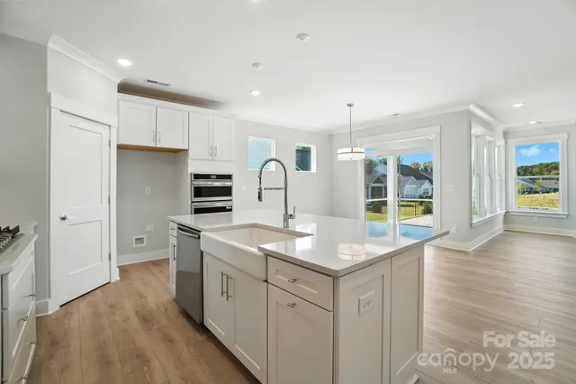 a kitchen with white cabinets sink and stove