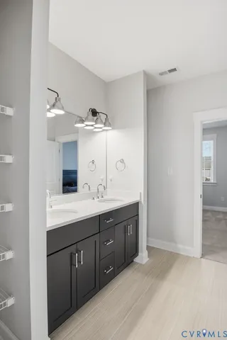 a spacious bathroom with a double vanity sink and mirror