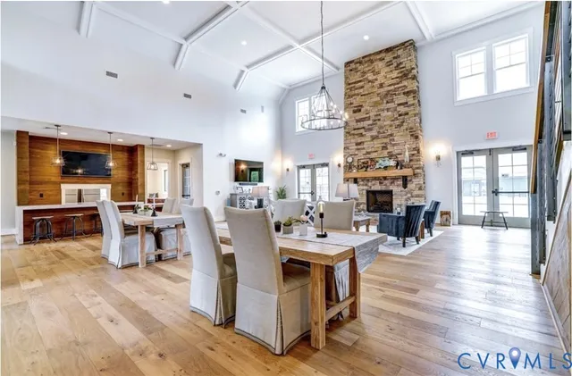 a view of center island of a kitchen with granite countertop living room a chandelier and living room view