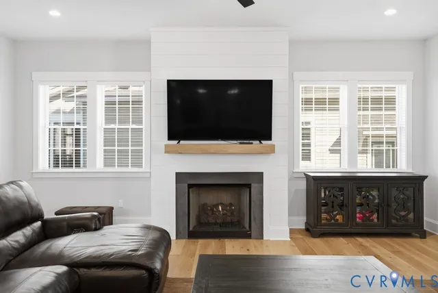 a living room with furniture a fireplace and a flat screen tv