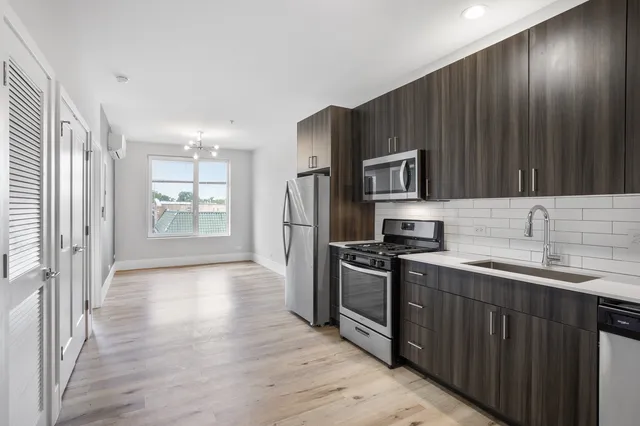 a kitchen with granite countertop wooden cabinets a refrigerator and a sink