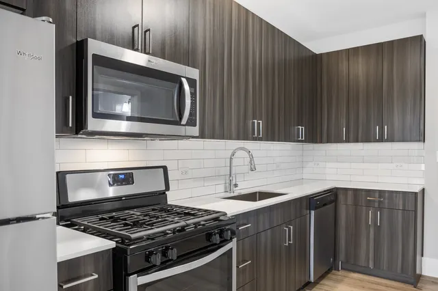 a kitchen with granite countertop a stove top oven cabinetry a sink and a oven