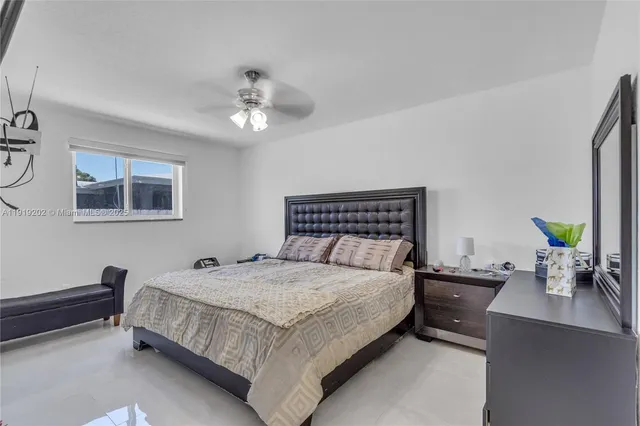 a bedroom with a bed chandelier and a window