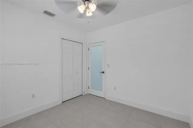 an empty room with a chandelier fan