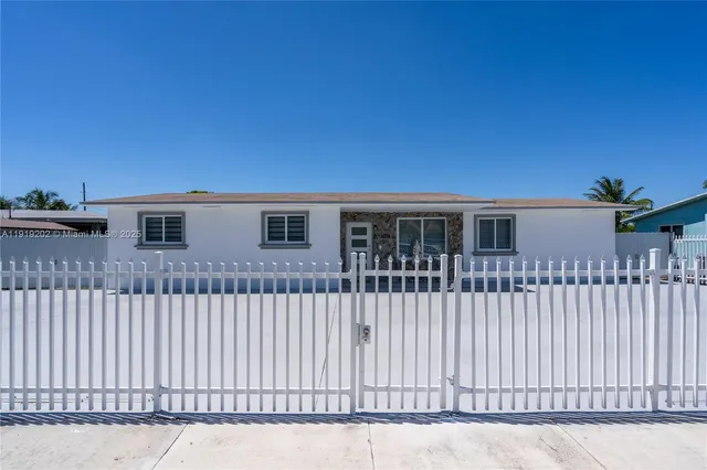 a view of a house with wooden fence