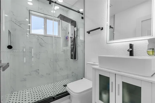 a bathroom with a sink toilet and shower
