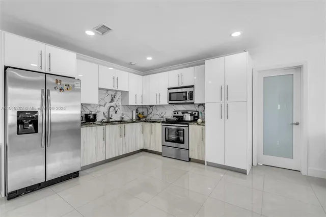 a kitchen with stainless steel appliances a refrigerator sink and microwave