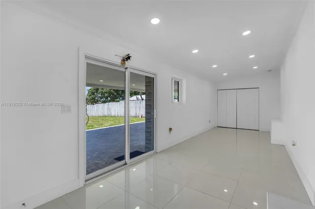 an empty room with sliding glass door and shower
