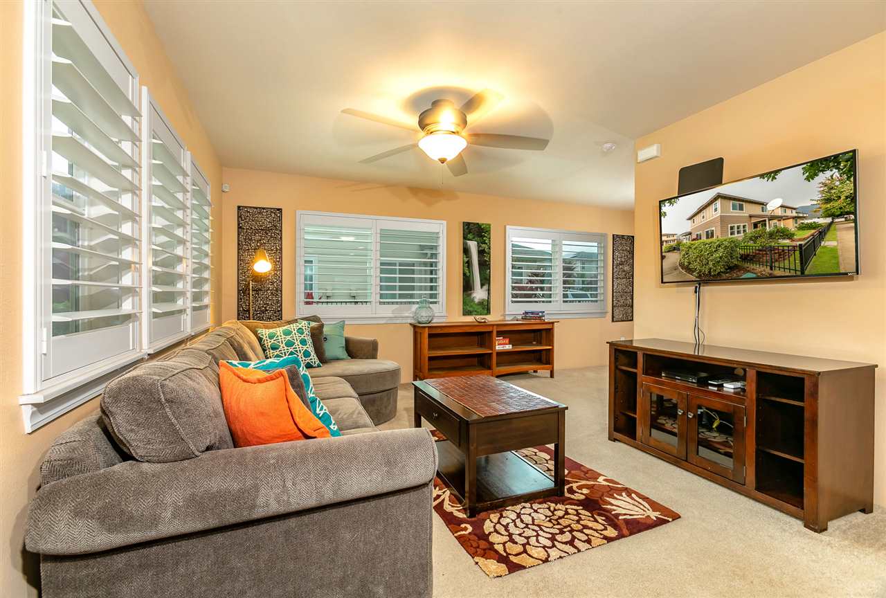 209 Alake Street Kahului, HI 96732 - Photo 4 of 30 a living room with furniture a flat screen tv and a floor to ceiling window