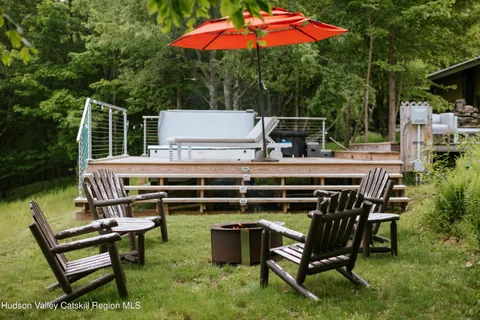 a roof deck with table and chairs under an umbrella