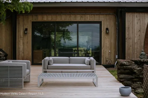 an outdoor sitting area with furniture and umbrella