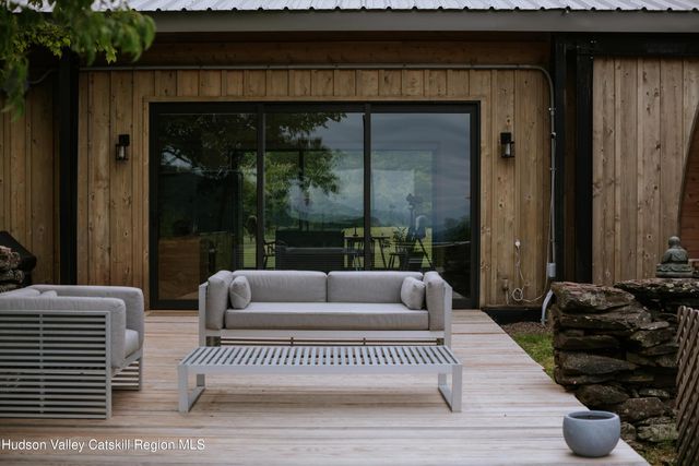 an outdoor sitting area with furniture and umbrella