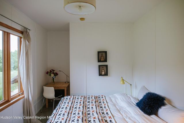 a bedroom with a bed and a painting on the wall