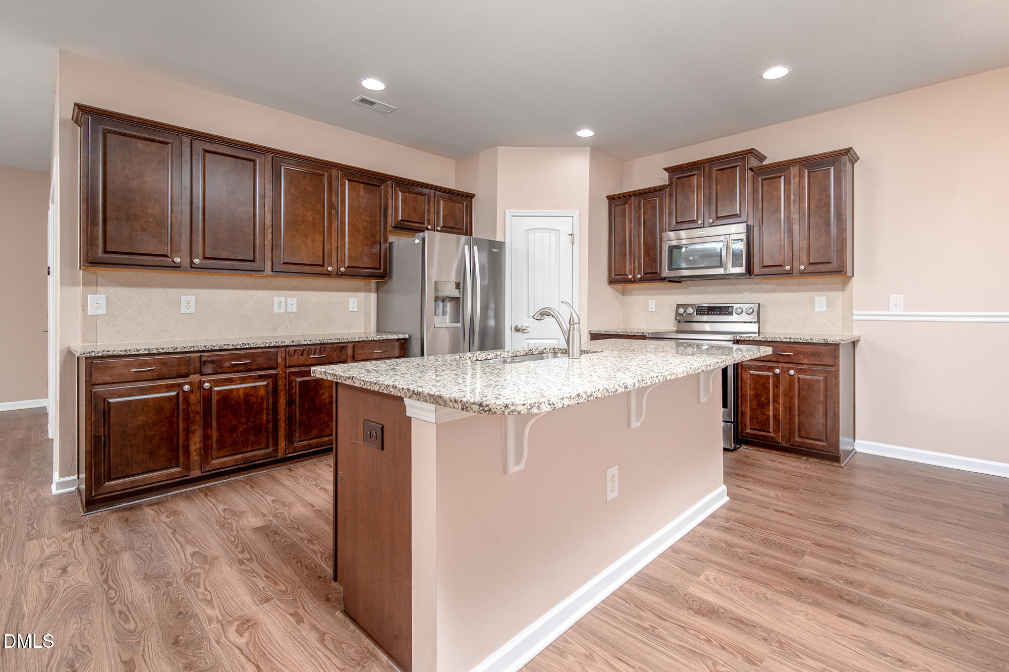 3548 Althorp Drive Raleigh, NC 27616 - Photo 11 of 56 a kitchen with stainless steel appliances granite countertop a stove a sink dishwasher a refrigerator and a microwave oven with wooden floor