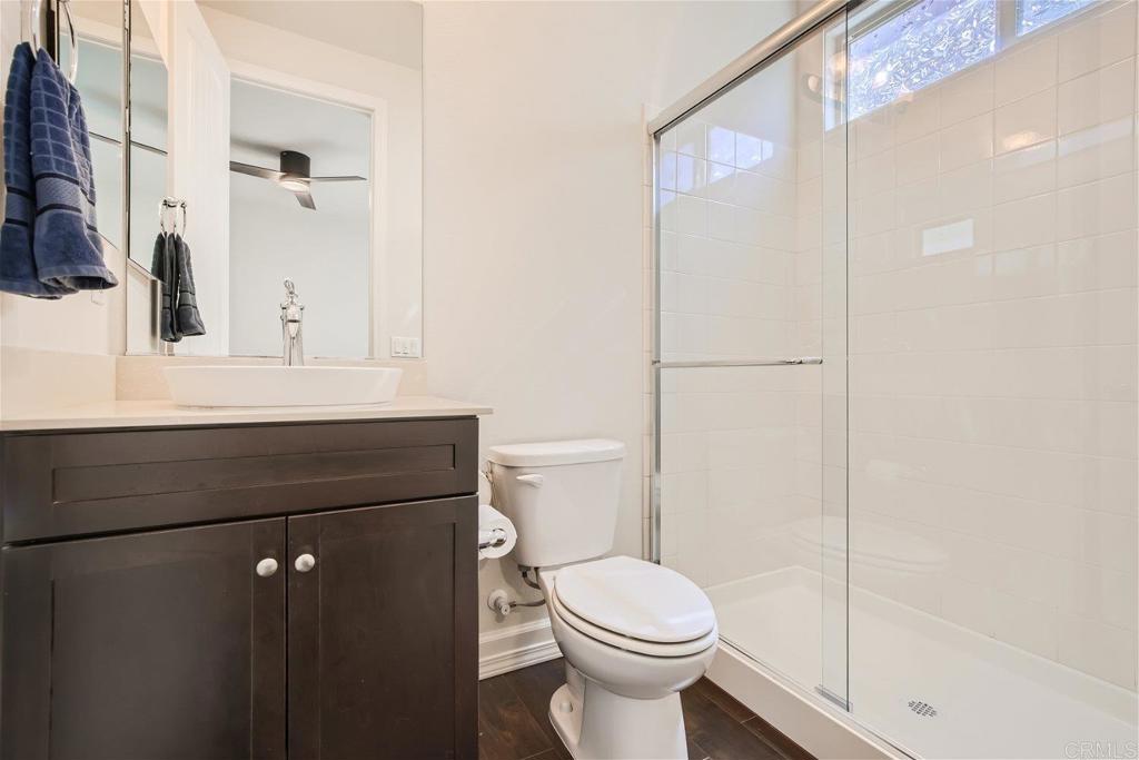 431 Machado Way Vista, CA 92083 - Photo 15 of 36 a bathroom with a sink a toilet a mirror and shower