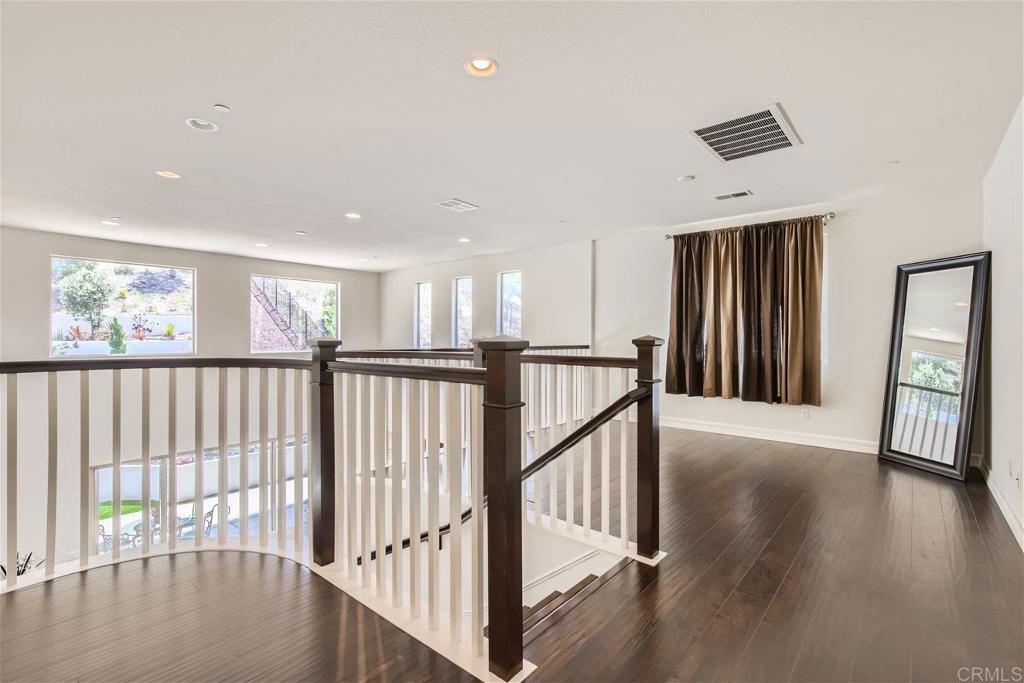 431 Machado Way Vista, CA 92083 - Photo 17 of 36 a view of a hallway with wooden floor and windows